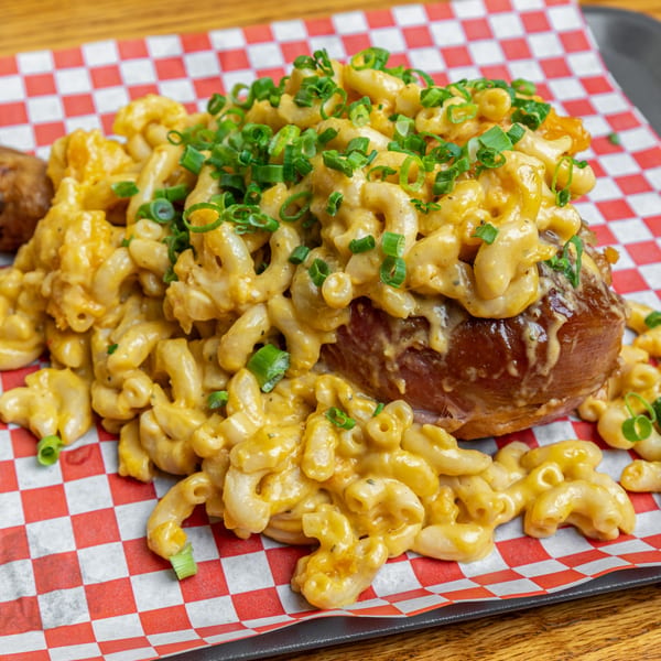 Hump's BBQ baked potato loaded with creamy mac and cheese, topped with green onions.