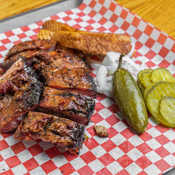 Hump's BBQ ribs, Texas toast, sliced onions, a whole pickled jalapeño, and pickle chips.